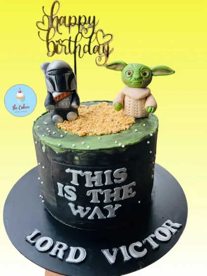 A Star Wars cake for a true fan, featuring 'The Mandalorian' and Grogu (Baby Yoda). This dark-themed cake includes the famous quote 'This is the Way' and is perfect for a galactic celebration.
