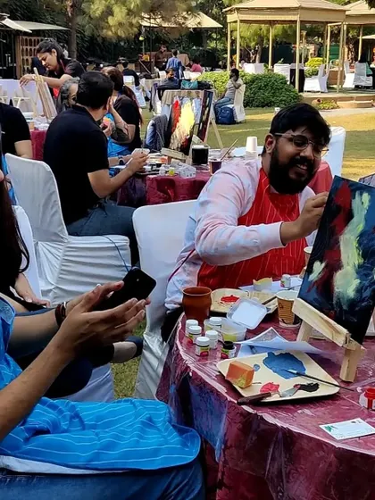 The joy of creation is evident on this participant's face. My workshops are all about letting go, having fun with colors, and enjoying the process of making art.