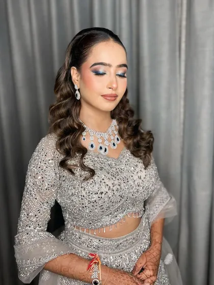 Cocktail glam with a hint of blue on the lower lash line to match her jewelry. It's all in the details.
