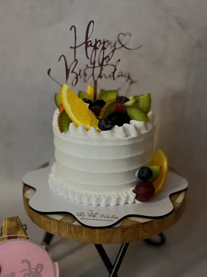 A classic and simple fresh fruit cake. The light whipped cream frosting is generously topped with a variety of seasonal fruits like oranges, kiwis, and berries.