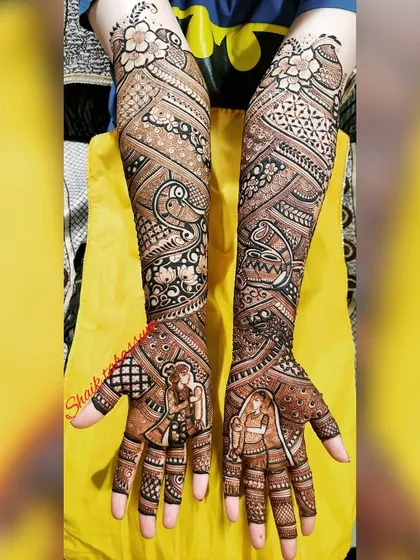 Intricate geometric and floral patterns fill the arms in this design, leading down to portraits of the bride and groom on each palm.