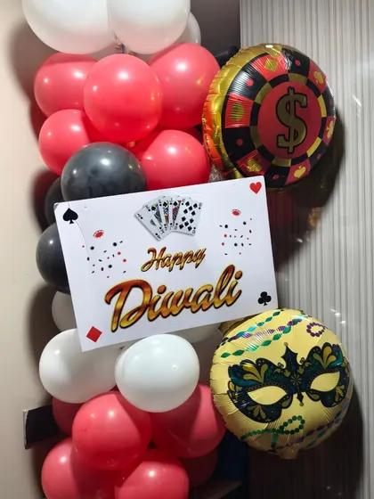 A close-up of a custom 'Happy Diwali' sign attached to a balloon pillar for a party.