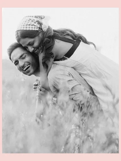 A playful piggyback ride through the tall grass. This black and white photo, with its soft focus, feels nostalgic and sweet, like a cherished memory from a perfect day.