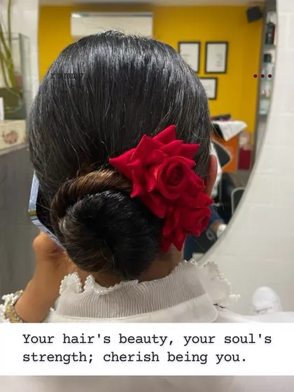 A classic sleek bun with a single red rose. This hairstyle is a testament to the idea that beauty lies in simplicity and strength.