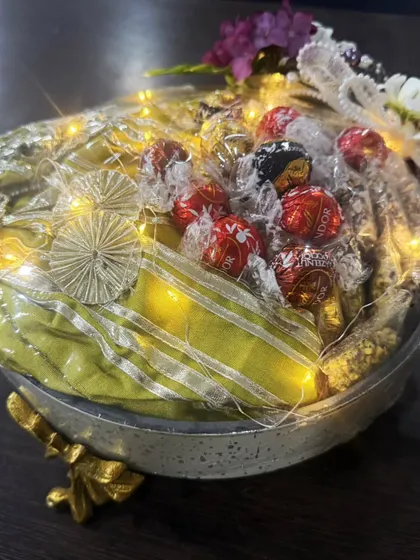 Another look at one of my signature illuminated gift hampers. This one is filled with assorted premium chocolates and other gourmet treats, all wrapped beautifully with a bow. It’s a gift designed to delight and impress.