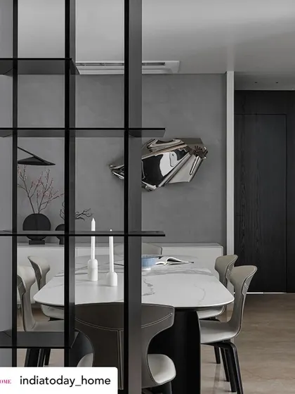 This perspective, seen through the room divider, creates a sense of discovery. The dining area and its feature art piece are revealed gradually, making the space feel more intimate and intriguing.