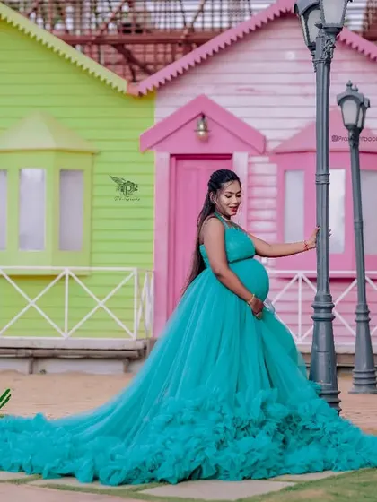 A vibrant maternity shoot with a colourful backdrop. This teal ruffled gown is one of my most popular rentals, and it looks absolutely stunning for celebrating motherhood.