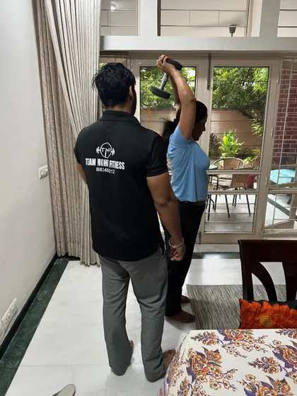 A home session focusing on triceps with an overhead dumbbell extension. My team and I provide hands on guidance.