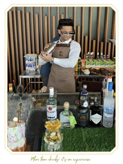 A stylish shot of our mixologist at work. The focus on premium spirits like Bacardi, Hendrick's, and Grey Goose highlights the quality ingredients we use.