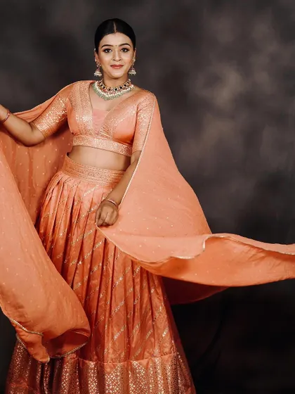 A dynamic shot showing the beautiful flow and light fabric of the peach lehenga, a great choice for a sangeet or reception.