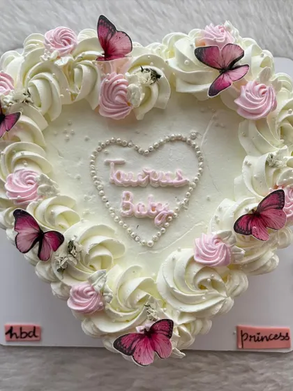 A top view of the "Taurus Baby" vintage heart cake, adorned with pink butterflies.