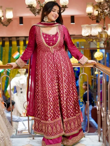 Own the outfit, own the spotlight. This beautiful magenta Anarkali-style suit with palazzo pants features rich brocade work, perfect for a wedding function.