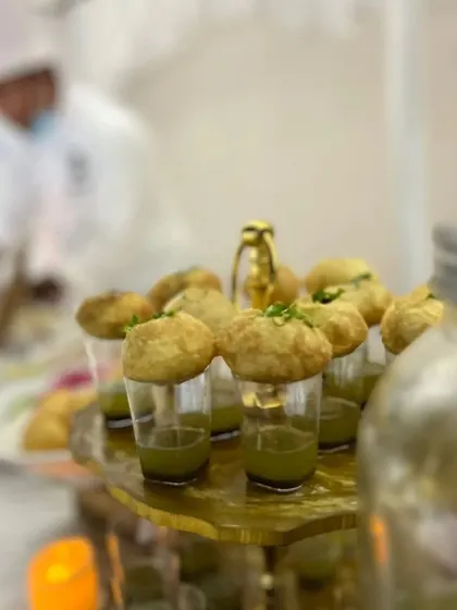 Another view of our modern pani puri shooters, with a chef visible in the background. This highlights the fresh preparation and elegant service of our live food stations.