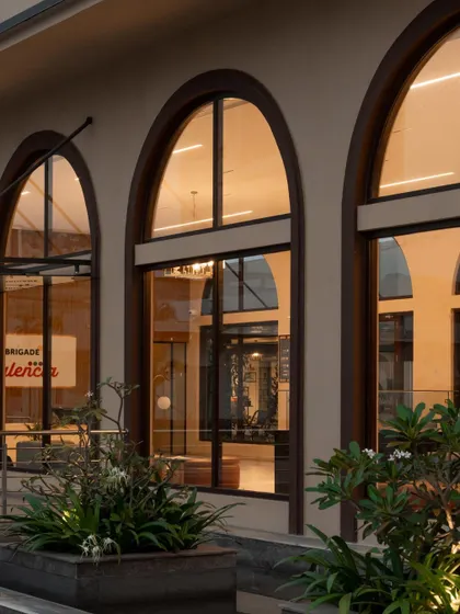 Another perspective of the illuminated arches at the Brigade Valencia office, showcasing the clean detailing and the inviting atmosphere created by the lighting design.