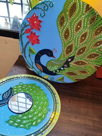 Here are two of my peacock themed Lippan creations side by side. One is a decorative wall plate, and the other is a functional mirror, both celebrating the beauty of the peacock.