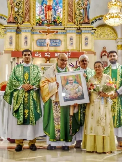 Another view of the presentation ceremony at the church, with me holding the certificate next to the group and my artwork.