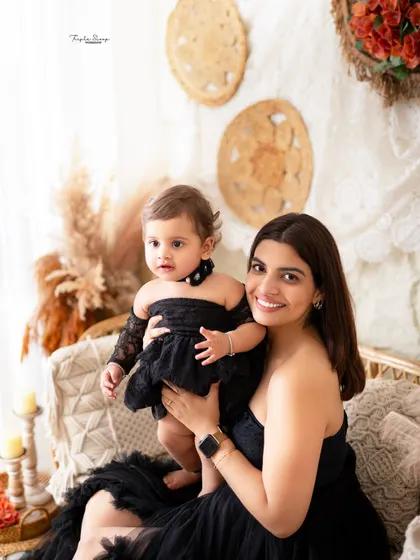 A beautiful mother holding her baby girl, both smiling and looking radiant. These mommy-and-me portraits are a perfect way to celebrate your connection.