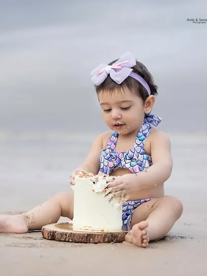 Getting right into it! This shot captures the moment of intense focus as she explores the texture of her first birthday cake.