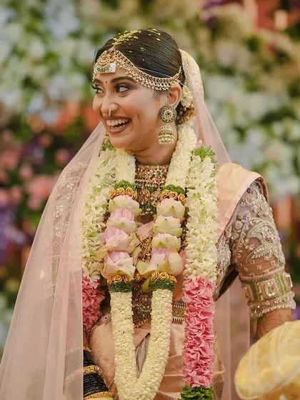 This bride looks radiant and happy on her special day. Her pastel ensemble is a perfect choice for a modern and elegant wedding.