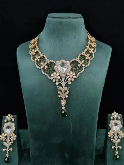 Your day, your dazzle. This elegant diamond-look set features a beautiful design with green stones and a central uncut diamond.