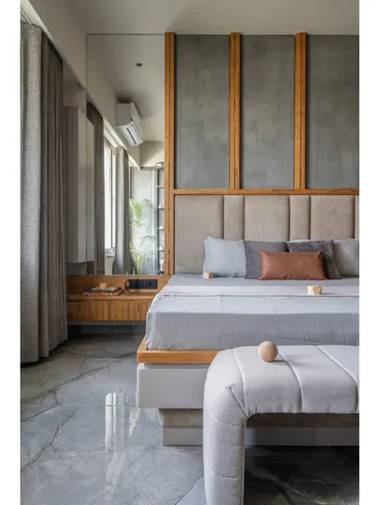 This view of the bedroom highlights the serene color palette of soft greys, natural wood, and muted blues. The design is clean and organized, with a focus on creating a restful environment through harmonious colors and textures.
