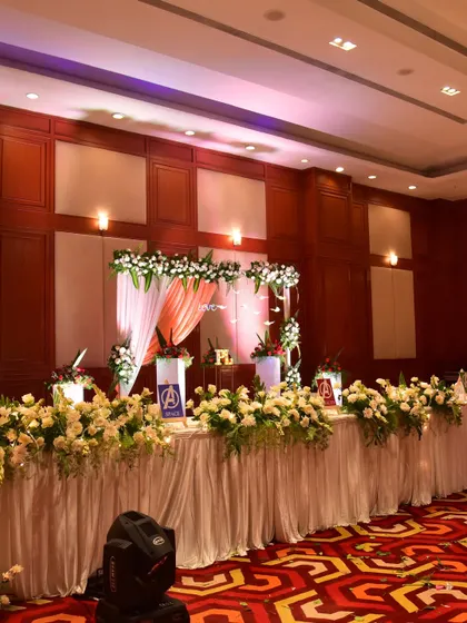 The main table at the Avengers-themed Sangeet, decorated with white flowers and the custom superhero signs.