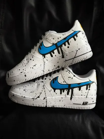 A custom Nike Air Force 1 with a blue dripping swoosh and black paint splatter.