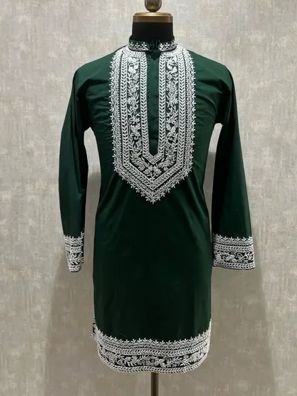 A dark green kurta with intricate white embroidery, a classic combination for any festive occasion.