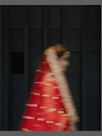 An artistic motion-blur shot of the bride in her red lehenga. This abstract image captures the feeling and movement of the day, turning a fleeting moment into a piece of art.
