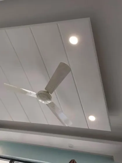 A simple yet elegant false ceiling design with recessed spotlights. This clean design adds a modern touch without lowering the ceiling height significantly.