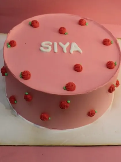 A simple and sweet cake for a naming ceremony. The delicate pink frosting and tiny red roses create a lovely design to welcome a new baby.