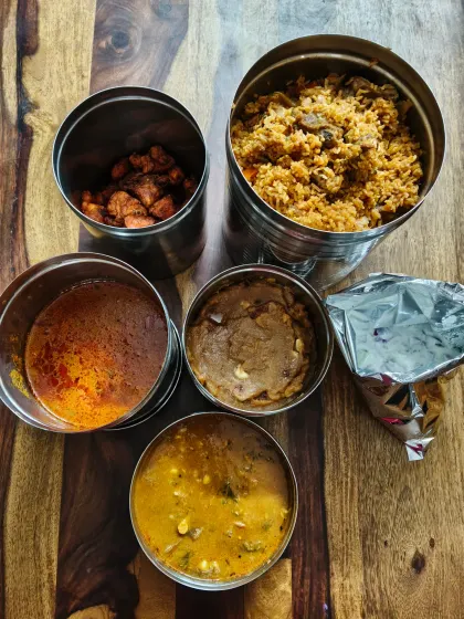 Mutton biryani, chicken kabab and gravies make up our order with raita, dhalcha and bread halwa.