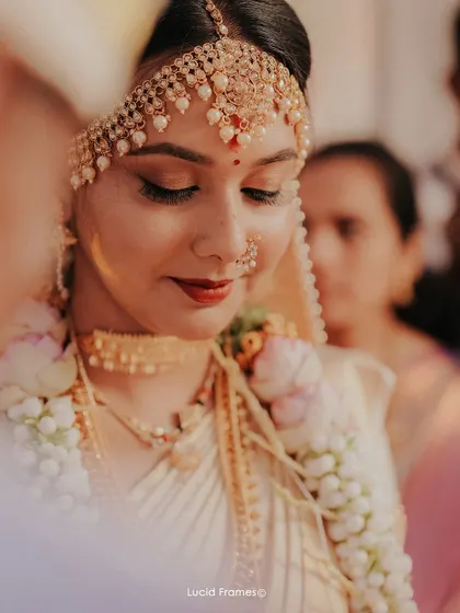A serene, downward-glancing portrait of the bride. This angle showcases her elegant eye makeup.