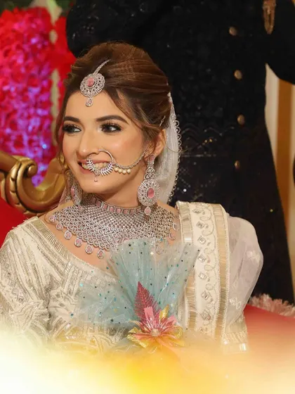 A radiant smile from the bride. Her makeup is soft and natural, with a focus on glowing skin and defined eyes that complement her diamond and pink stone jewelry.