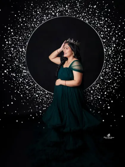 A fun and glamorous solo shot against our sparkling "starlight" backdrop. The mom-to-be's happy expression and confident pose are truly infectious.