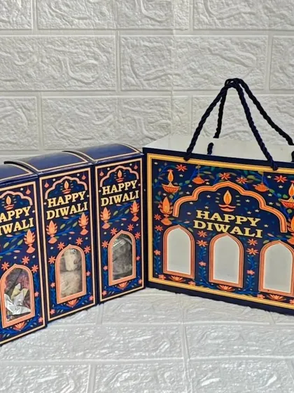 A still shot of the 'Happy Diwali' themed packaging set. This option includes three individual boxes that fit perfectly into a matching carry bag, ideal for distributing corporate gifts.