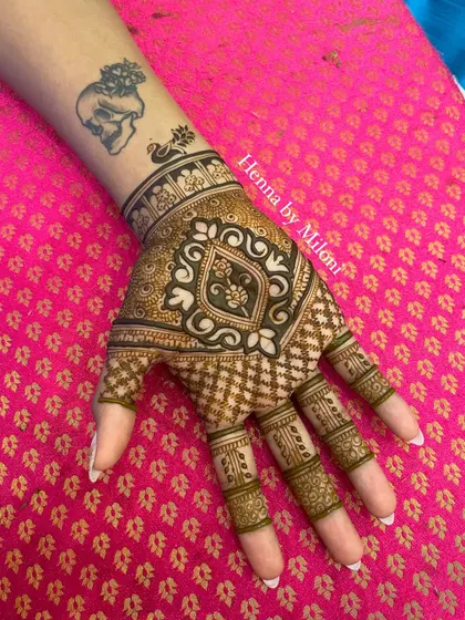 A chic design on the back of the hand, perfect for a party. It complements the client's existing tattoo beautifully.