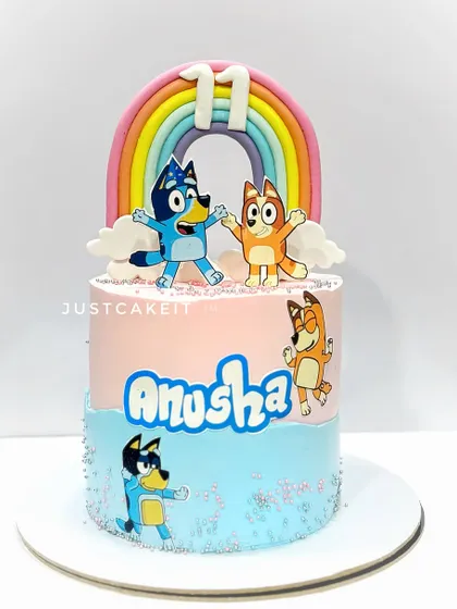 A Bluey-themed cake with edible characters and a pastel rainbow. This is a great example of a modern, popular kids' show theme.
