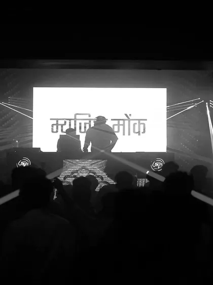 A black and white photo of me and a partner on stage, with my name in Hindi on the screen. This artistic shot shows a different, more reflective side of my performance.