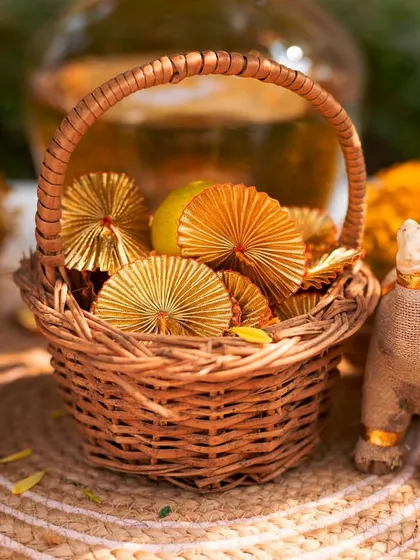 Small details for the Haldi, including a wicker basket with gota patti fans and miniature jute camels, adding a touch of Rajasthani-inspired craft.