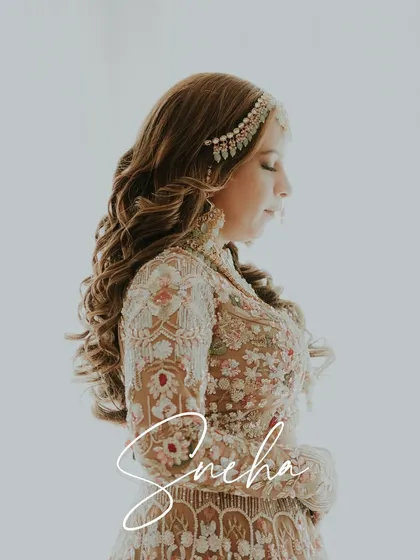 A beautiful, soft-focus portrait of a bride, her intricate lehenga and jewelry creating a look of pure radiance.