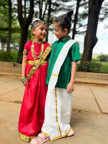 Finding it hard to handle this level of cuteness. Two of our youngest members, dressed in traditional South Indian attire, share a sweet look.