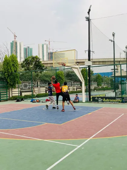 A contested shot under the hoop during a competitive evening game.