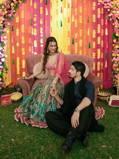 A classic romantic pose, capturing the couple's chemistry against the colorful Sangeet backdrop.