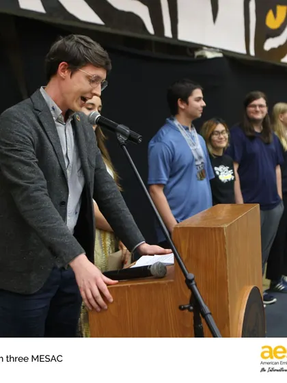 A coach from our Speech & Debate team addresses his students during the Season Three MESAC awards. Our activities extend to academic competitions, where students hone their public speaking and critical thinking skills.