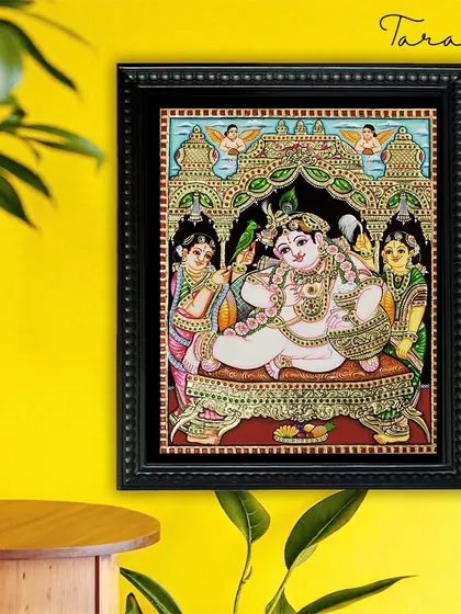 Our Butter Krishna Tanjore painting brings a joyful and spiritual ambiance to this modern living space. The contrast of the traditional artwork with the bright yellow wall creates a visually stunning effect.