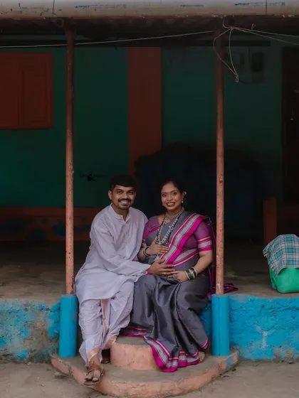 A happy portrait of the couple seated on the colorful porch. Their smiles show the joy and comfort they feel in this traditional setting.