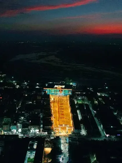 A stunning night-time aerial photograph of the Mantralaya temple complex, illuminated against the twilight sky. This shows my expertise in low-light drone photography to capture spiritual places in a unique way.