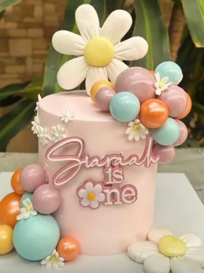 This layered acrylic "Siariah is one" cake charm sits beautifully on the side of the cake. It's a modern and stylish way to personalize your celebration cake.