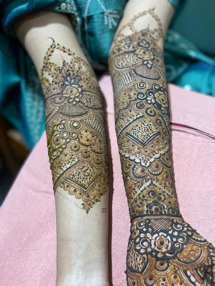 A view of two different but complementary bridal designs on both arms. One arm features heavy, traditional work while the other has a slightly more open pattern, showing how we can customize each side.